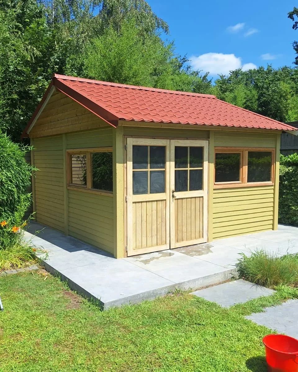 Afgewerkt houten tuinhuis met rode dakpannen